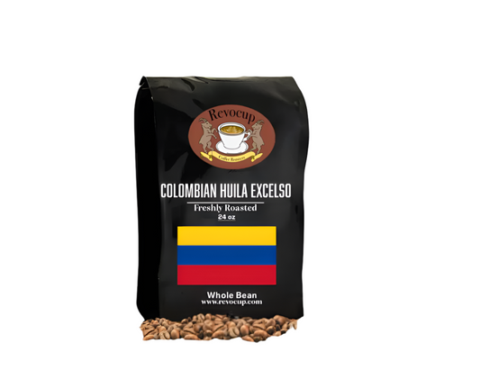 A black bag of Revocup Colombian Huila Excelso Whole Bean coffee, 24 oz, stands upright on a pile of roasted coffee beans.