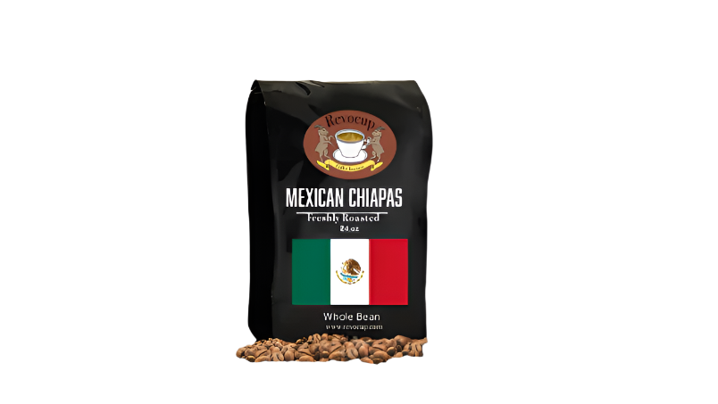 A black bag of Revocup Mexican Chiapas Whole Bean coffee, 24 oz, stands upright on a pile of roasted coffee beans.